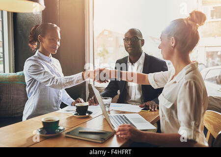 Schwarzen Business-Frau und weiße Geschäftsfrau Händeschütteln schließen einen Vertrag Stockfoto