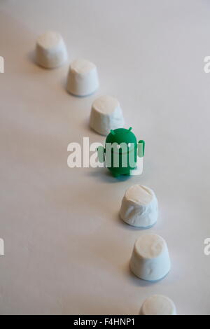 Ein grüner Android Roboter späht aus in einem Haufen von Marshmallows.  Googles Android OS ist unter dem Codenamen Marshmallow Stockfoto