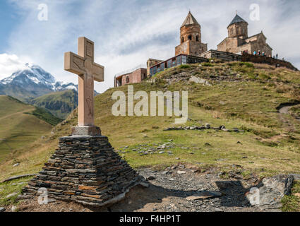 Kreuz und der zurGergeti Trinity Church in den Bergen des Kaukasus am nördlichen Georgien. Stockfoto