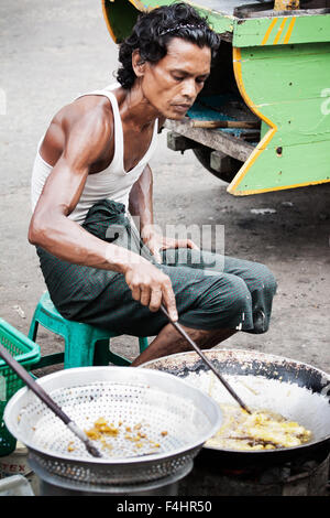 Street Fotografie Foto der burmesischen Mann braten Street Food auf den Straßen in Myanmar. Fast food, billig essen von einem kleinen Unternehmer Stockfoto