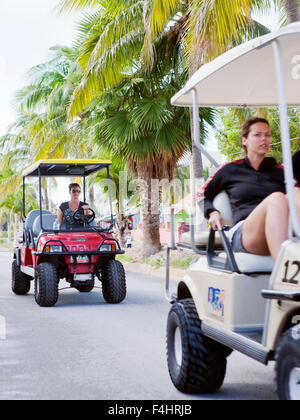 Touristen auf Golf-Carts, Isla Mujeres. Golf-Carts sind die wichtigste Quelle des Verkehrs auf der Insel. Stockfoto