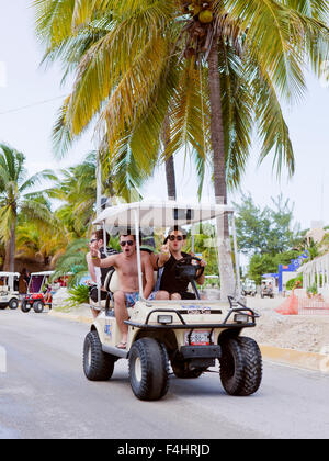 Touristen auf Golf-Carts, Isla Mujeres. Golf-Carts sind die wichtigste Quelle des Verkehrs auf der Insel. Isla Mujeres, Mexiko, Stockfoto