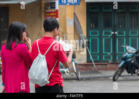 Asian paar Blick auf ihre Karte Reiseführer in Hanoi Old Quarter, Hauptstadt, Vietnam, Asien Stockfoto