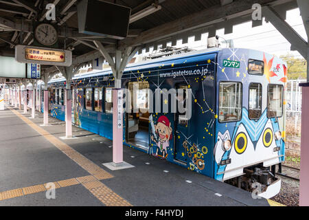 Iga Ueno, Japan. Kintetsu private Eisenbahn, Iga Tetsudo, Iga-Linie. Zug an Plattform, Außen von Kutschen mit bunten Comicfiguren eingerichtet. Stockfoto