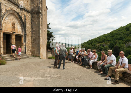 Besucher saßen außerhalb der Kirche Saint-Cirq-Lapopie, Midi-Pyrénées, Frankreich Stockfoto