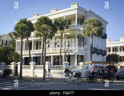 Charleston, South Carolina, USA. 16. Oktober 2015. Die Stadt Charleston South Carolina hat viele stattliche und traditionelle Häuser aus Stein, Ziegel und Schindeln oder Stufenfalz stehen noch aus der Zeit vor dem amerikanischen Bürgerkrieg sowie im amerikanischen Unabhängigkeitskrieg. Die meisten Häuser folgen einem ähnliches Muster von privaten und öffentlichen Bereichen, einschließlich Seite Balkone nutzen dessen, was heute noch den vorherrschenden Winden aus dem Atlantischen Ozean. ---Auf dem Foto eine Reitertour verläuft entlang East Battery Street vorbei White Point Garden in Charleston. © David Bro/ZUMA Draht/Alamy Live-Nachrichten Stockfoto