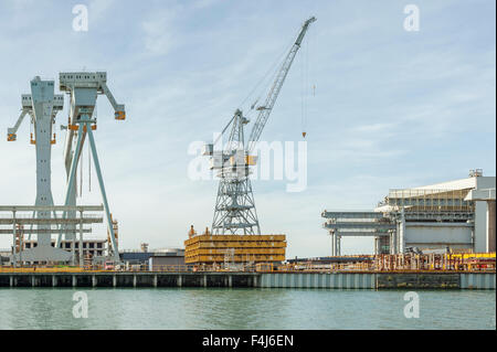 Verschiedene Arten von Kränen bei der Arbeit in einer Werft Stockfoto