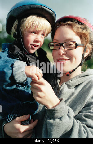 Eine Frau und ein kleiner Junge einen Fahrradhelm tragen. Stockfoto