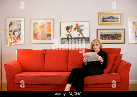 Ältere Frau liest auf sofa Stockfoto