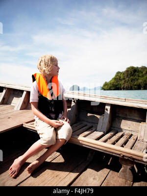 Thailand, junge tragen Rettungsring aus Fischerboot Stockfoto