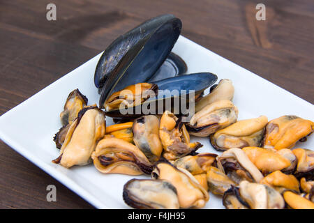 Muscheln ohne Schale auf Tablett auf Holztisch Nahaufnahmen Stockfoto