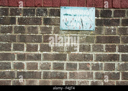 Eine Wand mit einer Zeichen-Warnung. Anti-Vandal Farbe Warnung Stockfoto