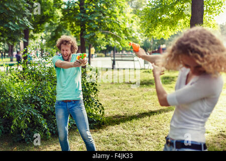 Freunde spielen mit Wasserpistolen im park Stockfoto