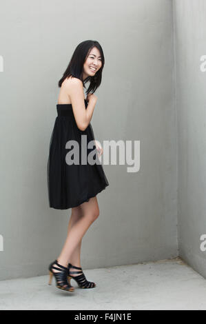 Frau trägt schwarzes Kleid, lachen Stockfoto