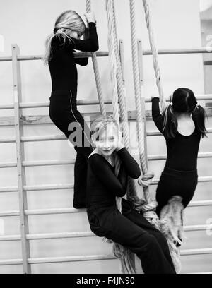 Schweden, Stockholm, Mädchen (6-7) klettern am Seil im gymnasium Stockfoto