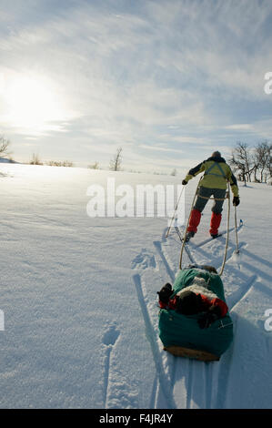 Mutter Schlitten mit Sohn einziehen Stockfoto