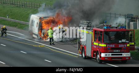 Feuerwehrleute aus einem van Feuer auf der Autobahn Stockfoto