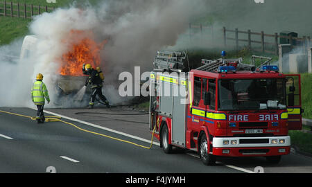 Feuerwehrleute aus einem van Feuer auf der Autobahn Stockfoto