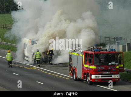 Feuerwehrleute aus einem van Feuer auf der Autobahn Stockfoto