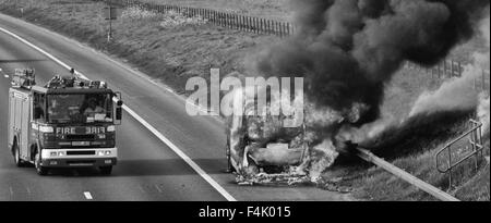 Feuerwehrleute aus einem van Feuer auf der Autobahn Stockfoto