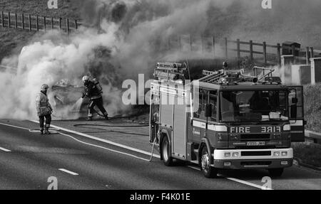 Feuerwehrleute aus einem van Feuer auf der Autobahn Stockfoto