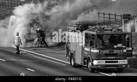 Feuerwehrleute aus einem van Feuer auf der Autobahn Stockfoto