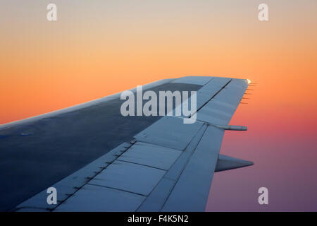 Flugzeugflügel auf Sonnenuntergang Stockfoto