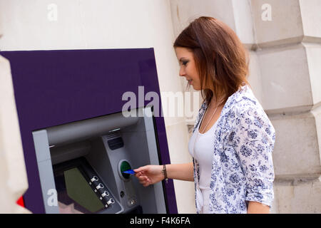 junge Frau bei der Geldautomat Stockfoto