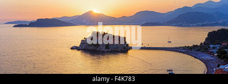 Rosa Sonnenuntergang und kleine Insel Sveti Stefan Meer Blick von oben (Montenegro, Budva). Alle Menschen sind nicht erkennbar. Stockfoto