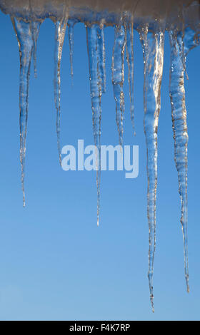 Eiszapfen auf einem Gesims im Frühjahr an einem sonnigen Tag Stockfoto