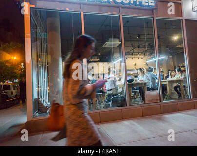 Kunden profitieren von kostenfreiem WLAN im Bean & Bean Coffee Shop in Chelsea in New York auf Dienstag, 13. Oktober 2015. Das kostenlose WLAN und die Gemeinschaftstischen Heranziehung die der Coffee-Shop als ein Coworking-Space. (© Richard B. Levine) Stockfoto