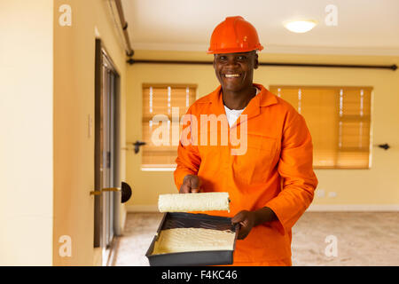 Porträt von glücklich afrikanischen Builder halten Farbroller und Farbe Stockfoto