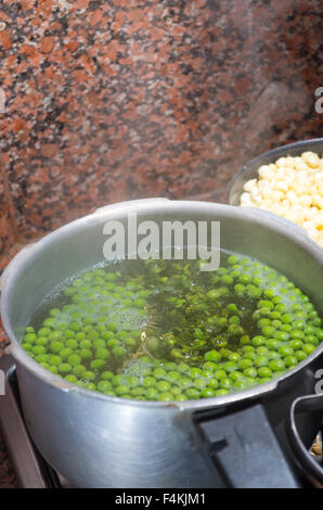 Grüne Erbsen in Silber farbigen Metall-Topf kochen. Fanesca Vorbereitung Konzept Stockfoto