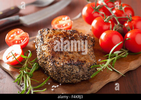 Rindersteak mit Gewürzen und Rosmarin auf hölzernen Hintergrund Stockfoto