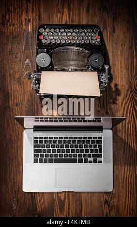 Alte Schreibmaschine mit Laptop, Konzept der Technologiefortschritt Stockfoto