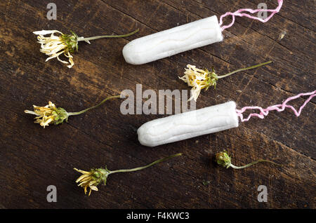 Sauberen, weißen Tampons auf Holzoberfläche mit farbigen trockenen Blüten herum liegen Stockfoto