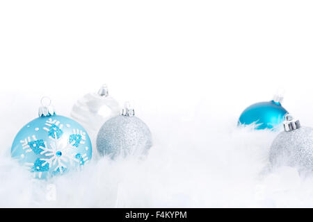 Blau und Silber Weihnachtskugeln auf eine weiche federleichte Oberfläche mit einem weißen Hintergrund. Stockfoto