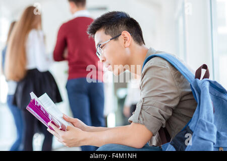 Porträt eines jungen männlichen Studenten lesen Buch in Universität Halle Stockfoto