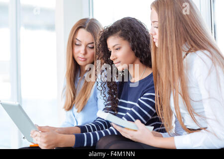 Porträt einer drei Schüler Frau mit Tablet-PC auf der Universität Halle Stockfoto