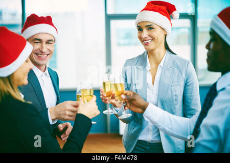 Glücklich Büroangestellte in Santa Caps Toasten Christmas Party Stockfoto