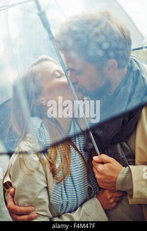 Verliebter Mann und Frau küssen unter Dach Stockfoto