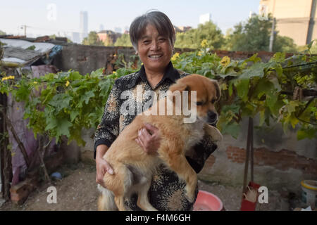 Beijing, Chinas Provinz Anhui, China. 18. Oktober 2015. 60-j hrige Dong Chenglan, die alleine leben, hält ihren Hund namens Huanghuang auf dem Hof in Hefei, Hauptstadt der Osten Chinas Provinz Anhui, 18. Oktober 2015. Bis zum Ende des Jahres 2014 war die Zahl der chinesischen Senioren über 60 Jahre alt 212 Millionen, etwa 15,5 Prozent der Gesamtbevölkerung des Landes. Heute bevorzugen immer mehr älteren Menschen in China, Haustiere zu erhöhen, die nachweislich positiven Beitrag zu einer Senioren Leben. © Zhang Duan/Xinhua/Alamy Live-Nachrichten Stockfoto