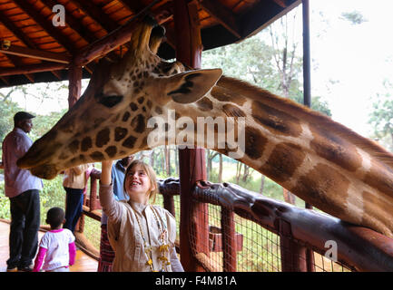 Nairobi, Kenia. 20. Oktober 2015. Eine Mädchen berührt eine Giraffe im Giraffe Centre in Nairobi, Kenia, 20. Oktober 2015. Giraffe Centre, gegründet 1979, ist Teil einer Bewegung, die versucht, Giraffen, mit einige Giraffen Arten derzeit in Gefahr zu retten. Menschen können hier Kontakt mit Giraffen haben. © Pan Siwei/Xinhua/Alamy Live-Nachrichten Stockfoto