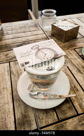 Tasse Bio-Tee mit Teebeutel und moderne Löffel auf Holztisch. Stockfoto