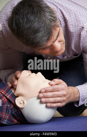 Mann In erste-Hilfe-Kurs Atemwege auf CPR Dummy Prüfung Stockfoto