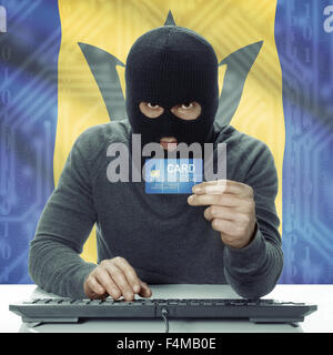 Dunkel-enthäutete Hacker mit Kreditkarte in der Hand und Flagge auf Hintergrund - Barbados Stockfoto