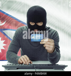 Dunkel-enthäutete Hacker mit Kreditkarte in der Hand und Flagge auf Hintergrund - Nepal Stockfoto