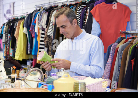 Männlichen Shopper im Secondhand-Laden schauen Ornamente Stockfoto