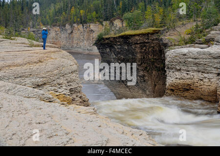 Frau mit Kamera mit Blick auf Sambaa Deh Fälle am Forellenfluss, Sambaa Deh fällt Territorial Park, NWT, Kanada Stockfoto