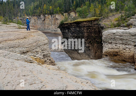 Frau mit Kamera mit Blick auf Sambaa Deh Fälle am Forellenfluss, Sambaa Deh fällt Territorial Park, NWT, Kanada Stockfoto